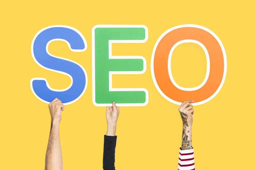 Manos sosteniendo letras de colores que forman la palabra SEO